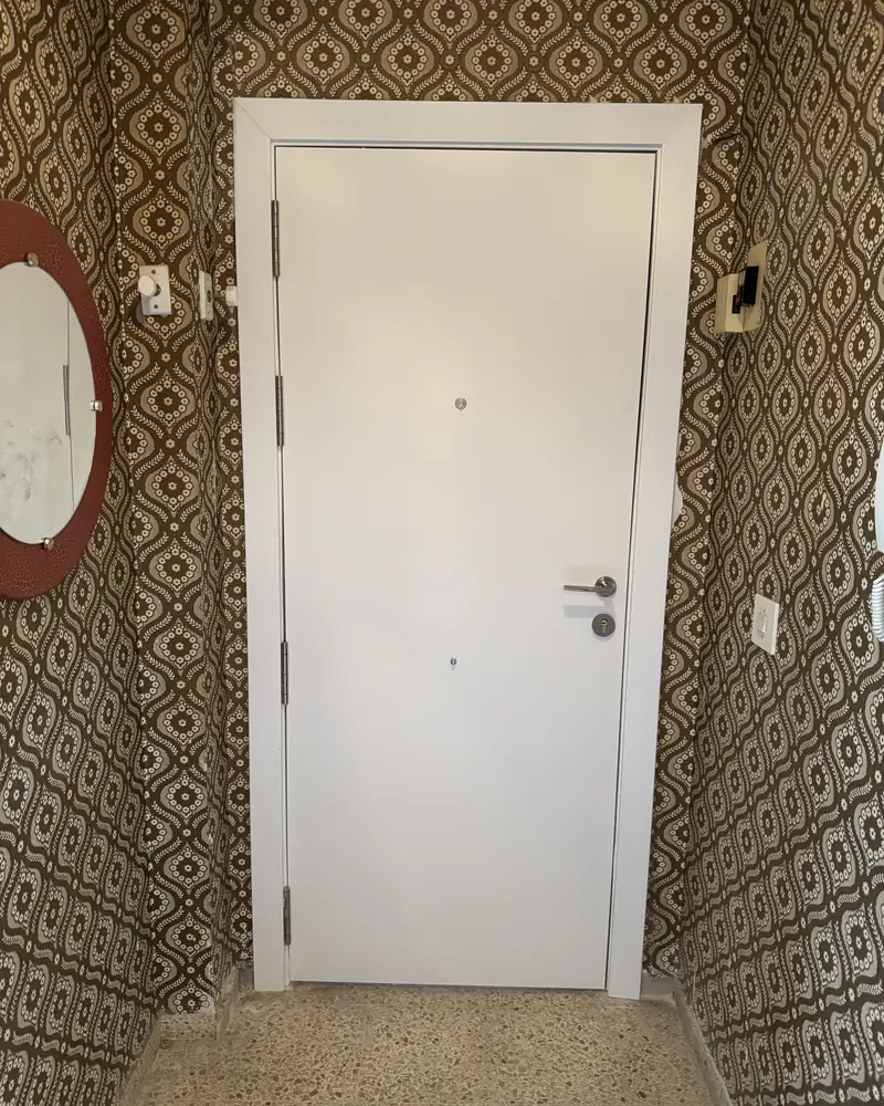 Después: Cerrajería: puerta forzada en un intento de robo, sustituida por una puerta de seguridad